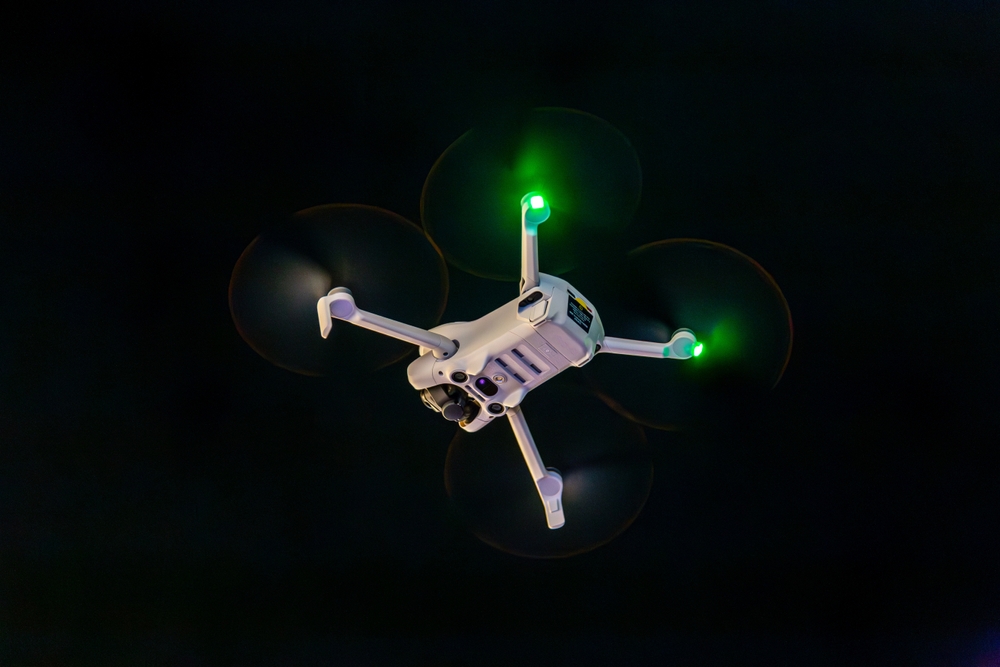 White drone flying at night